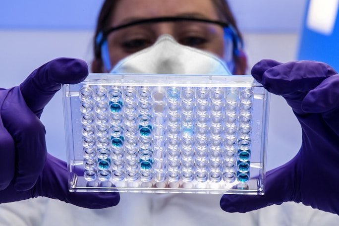 A researcher holding a laboratory well plate
