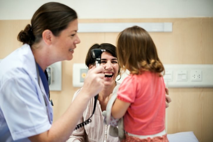 A doctor examining a smiling child