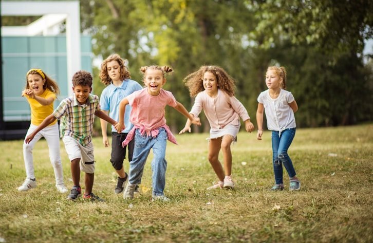 A group of children running on the grass