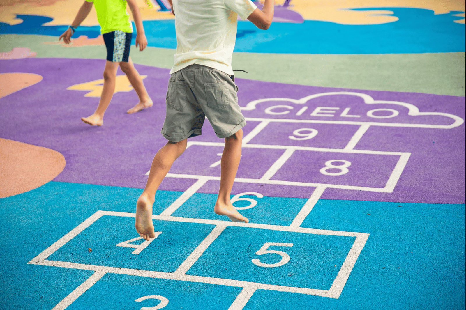 A child playing hopscotch in a brightly coloured playground